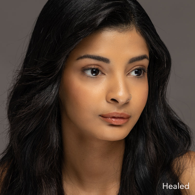 A model with healed lips showcasing the results of using the Orange Coral - Tina Davies Lust Lip color, emphasizing a natural but vibrant look.